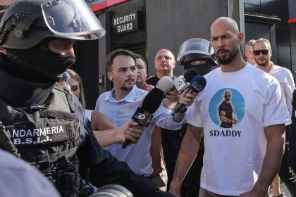 Romanian gendarmes from the Special Intervention Brigade escort Andrew Tate outside the Tate brothers' residence in Pipera, Ilfov, near Bucharest on August 21, 2024.