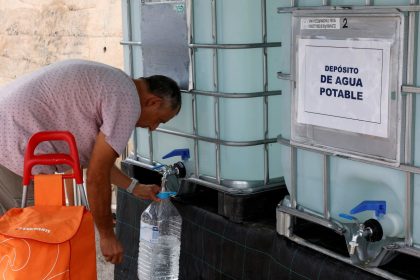 A resident collects water from a tank on August 19, as tap water has been declared undrinkable in the town of Teulada, Alicante, Spain.