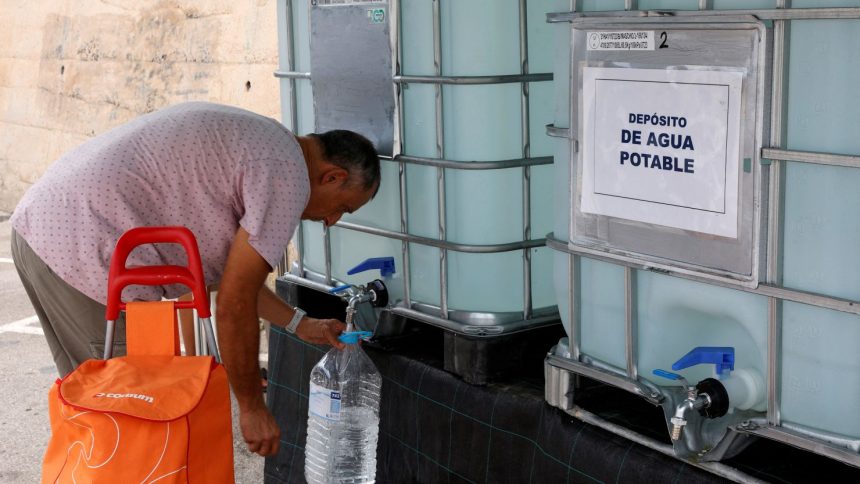 A resident collects water from a tank on August 19, as tap water has been declared undrinkable in the town of Teulada, Alicante, Spain.