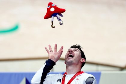 Jaco van Gass celebrates on the podium after taking the gold medal in the men's C3 3000m individual pursuit final.