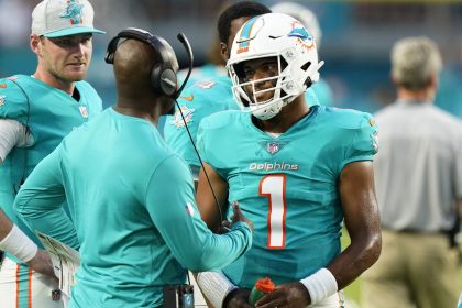 Tua Tagovailoa (right) talks to Brian Flores (left) during a Miami Dolphins preseason game against the Atlanta Falcons in 2021.