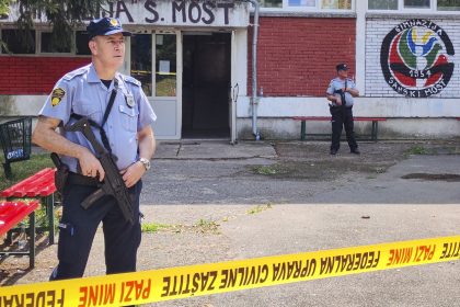 Police officers stand in front of the school building in Sanski Most, northwest of Bosnia's capital, Sarajevo on Wednesday.