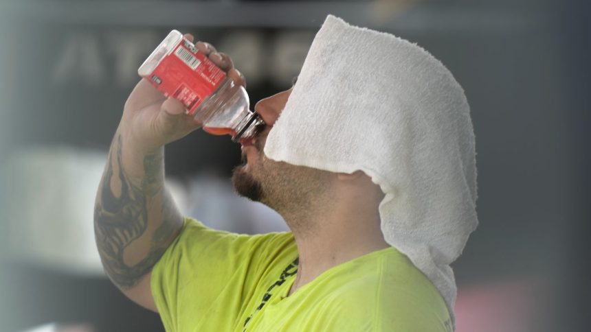 A construction worker hydrates at the Shedd Aquarium Tuesday, Aug. 27, 2024, as a second straight day of hot soupy temperature hung over much of the Midwest in Chicago.