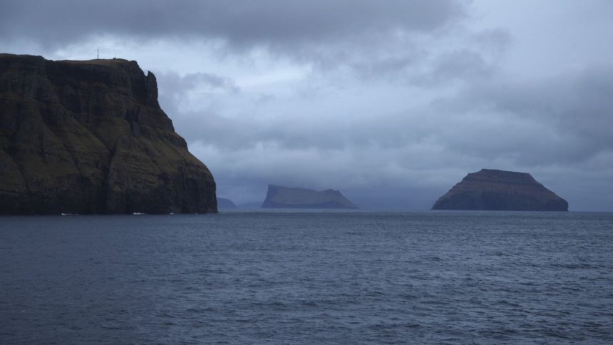 ILLUSTRATION - 08 March 2021, Faroe Islands, Tvoroyri: Cliffs of the Faroese island of Suduroy and several offshore islands can be seen from a ship that has left the port of Tvoroyri. Photo by: Steffen Trumpf/picture-alliance/dpa/AP Images