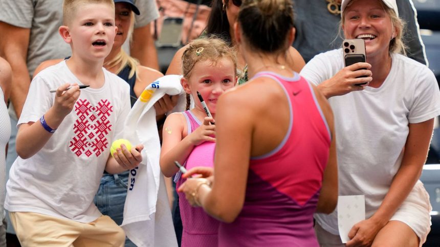 Aryna Sabalenka signs autographs for fans, including for a young fan dressed up like her, after defeating Lucia Bronzetti in the second round of the US Open.