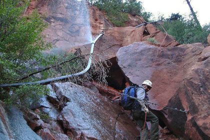 Water sprays from a break in an exposed section of the Transcanyon Waterline as a worker attempts repairs in this undated photo provided by the National Park Service.