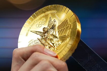 Chinese swimmer Pan Zhanle shows his gold medal after winning men's 100m freestyle final at the Paris Olympics on July 31, 2024.