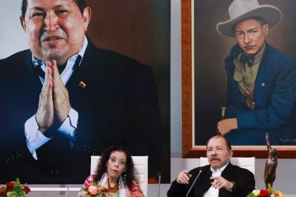 Nicaraguan President Daniel Ortega, above next to his wife and Vice President Rosario Murillo, and in front of a giant photo of the late Venezuelan former President Hugo Chavez, takes part in a virtual summit in Managua, Nicaragua, on August 26, 2024.