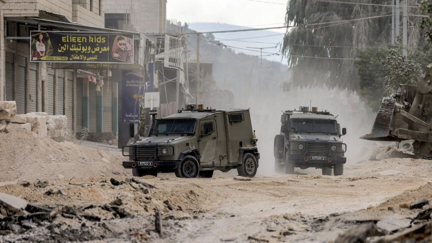 Israeli army armoured vehicles move along a road during a military operation in Tulkarm in the north of the occupied West Bank on August 29, 2024. Israel on August 28 launched a large-scale operation in the occupied West Bank where the military said it killed Palestinian fighters, as the nearly 11-month-old Gaza war showed no signs of abating. (Photo by Jaafar ASHTIYEH / AFP) (Photo by JAAFAR ASHTIYEH/AFP via Getty Images)