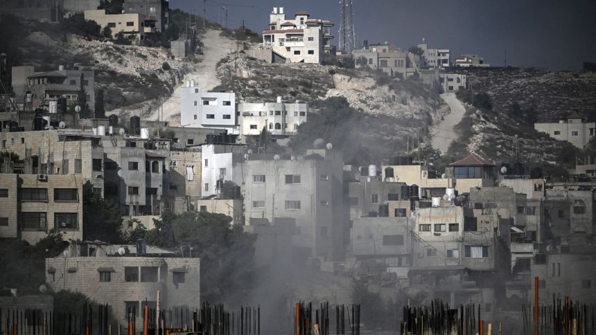 Smoke rises among buildings during an Israeli army raid in Jenin in the occupied West Bank on August 30, 2024. An Israeli air strike hit the occupied West Bank as its large-scale military operation entered a third day, with the military killing at least 16 Palestinians. (Photo by RONALDO SCHEMIDT / AFP) (Photo by RONALDO SCHEMIDT/AFP via Getty Images)