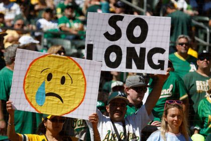 Oakland A's fans holding up signs bidding farewell to the team in their final game at the Oakland Coliseum