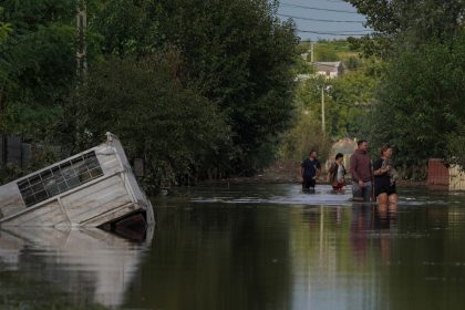 People walk on a flooded road after heavy rain triggered flooding in Cuza Voda, Galati county, Romania, September 15, 2024.