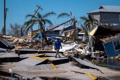 TOPSHOT - A man walks over a broken section of the Pine Island Road in the aftermath of Hurricane Ian in Matlacha, Florida on October 1, 2022. - Shocked Florida communities counted their dead October 1, 2022, as the full scale of the devastation came into focus, two days after Hurricane Ian tore into the coastline as one of the most powerful storms ever to hit the United States.