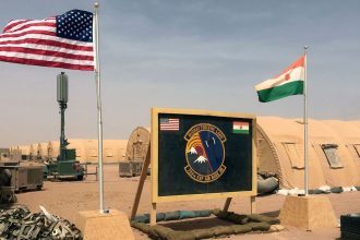 In this April 2018 file photo, US and Niger flags are raised side by side at the base camp for air forces and other personnel supporting the construction of Niger Air Base 201 in Agadez, Niger.