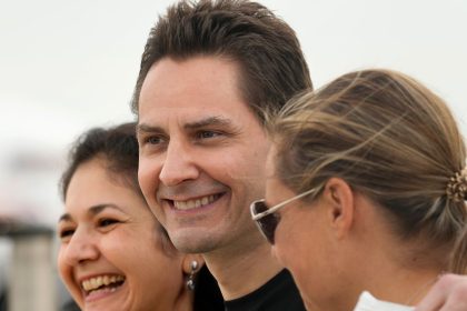 Michael Kovrig embraces his separated wife Vina Nadjibulla and sister Ariana Botha after arriving at Pearson International Airport in Toronto, on September 25, 2021.