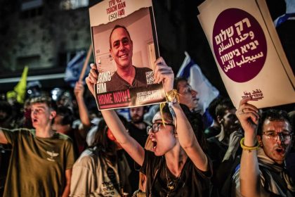 A protester holds up a photo of Tsachi Idan, 50, who is being held hostage by Hamas in Gaza, following the funeral of Hersh Goldberg Polin.