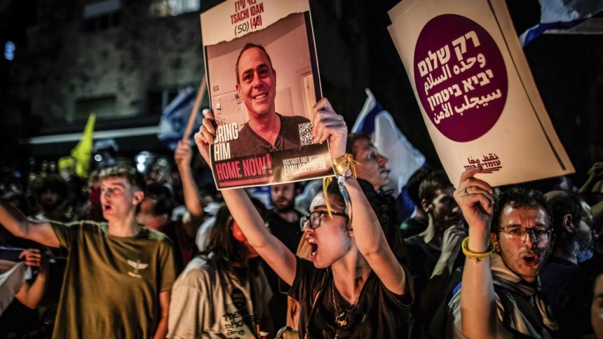 A protester holds up a photo of Tsachi Idan, 50, who is being held hostage by Hamas in Gaza, following the funeral of Hersh Goldberg Polin.