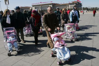 Spanish couples take their newly adopted Chinese children for a walk in Beijing's Tiananmen Square on March 7, 2007.