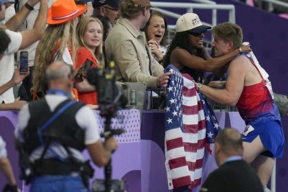 After winning gold in the men's 400m T62, US sprinter Hunter Woodhall hugs his wife Tara Davis-Woodhall at the 2024 Paralympics.