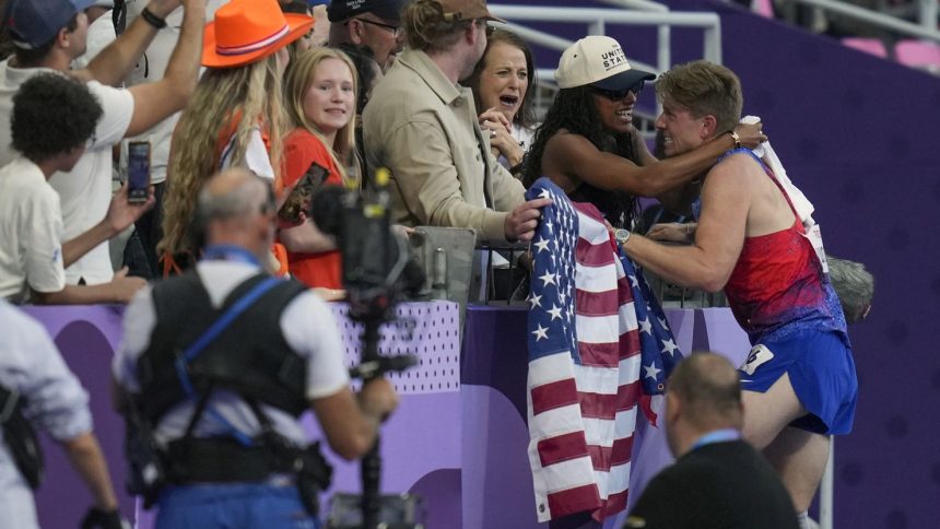 After winning gold in the men's 400m T62, US sprinter Hunter Woodhall hugs his wife Tara Davis-Woodhall at the 2024 Paralympics.