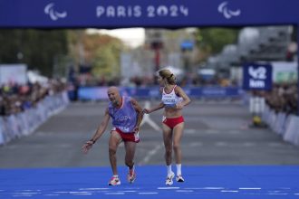 Mia Carol stumbles as he and Elena Congost approach the finish line in the women's T12 marathon.