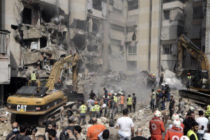 Emergency workers use excavators to clear the rubble at the site of Friday's Israeli strike in Beirut's southern suburbs, Saturday, Sept. 21, 2024.