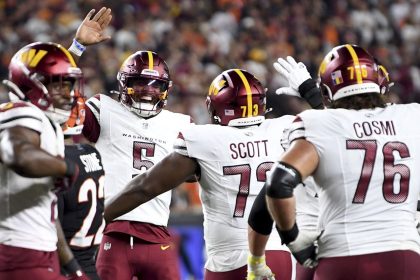 Jayden Daniels (5) celebrates throwing a touchdown pass to offensive tackle Trent Scott (73) against the Cincinnati Bengals.