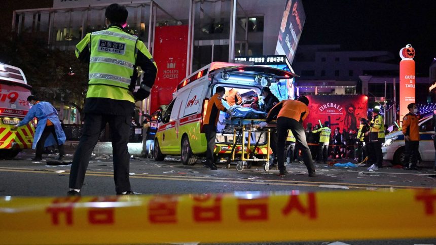 Medical staff attend to a person on a stretcher in the popular nightlife district of Itaewon in Seoul on October 30, 2022, after thousands of people crowded into the neighborhood's narrow streets to celebrate Halloween.