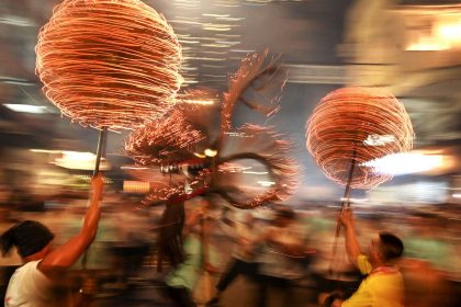 Members of a fire dragon dance team spin balls of joss sticks in Hong Kong.