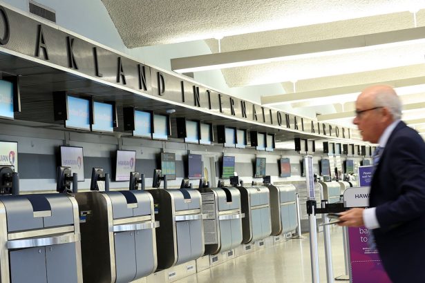 A traveler walks through San Francisco Bay Oakland International, whose IATA code is still OAK.