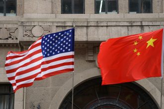 The national flags of the United States and China flutter at the Fairmont Peace Hotel on April 25, 2024 in Shanghai, China.