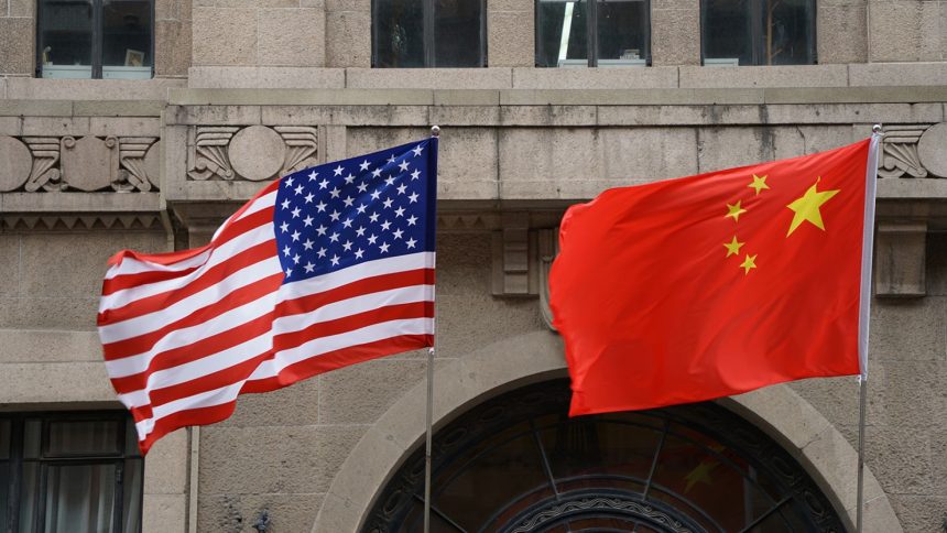 The national flags of the United States and China flutter at the Fairmont Peace Hotel on April 25, 2024 in Shanghai, China.