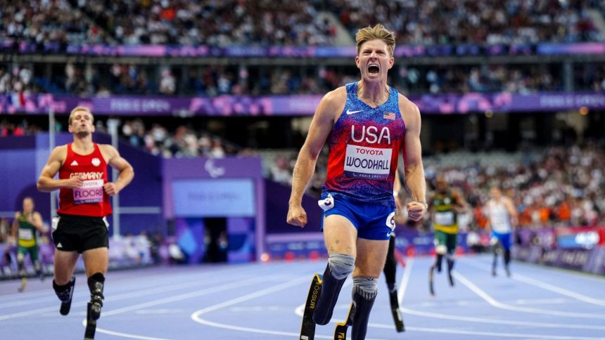 US' Hunter Woodhall celebrates after winning the gold medal during the Men's 400m T62 final event at the Paris 2024 Paralympic Games at the Stade de France in Saint-Denis, outside Paris on September 6, 2024. (Photo by Dimitar DILKOFF / AFP) (Photo by DIMITAR DILKOFF/AFP via Getty Images)