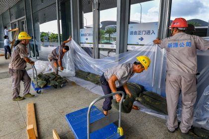 Staff members bracing for Super Typhoon Yagi arrange sandbags at the Xinhai Port on September 4 in Haikou, Hainan.