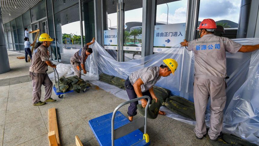 Staff members bracing for Super Typhoon Yagi arrange sandbags at the Xinhai Port on September 4 in Haikou, Hainan.