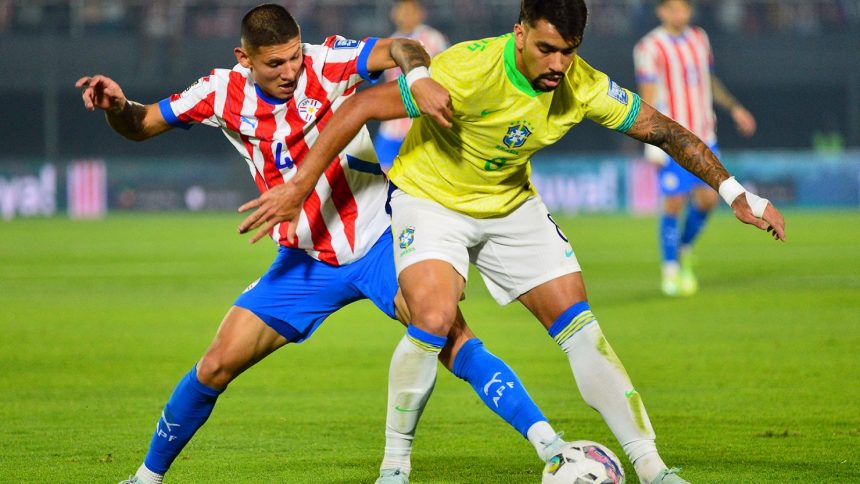 Brazil's Lucas Paquetá tries to shield the ball from Paraguay's Juan Cáceres.