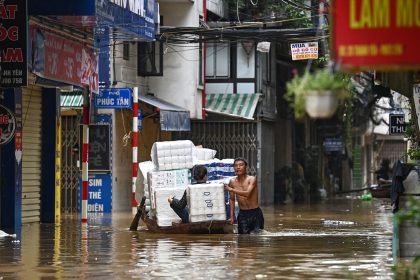 People transport basic commodities on a boat through flood waters on a street in Hanoi on September 12, 2024, as heavy rains in the aftermath of Typhoon Yagi brought flooding to northern Vietnam.