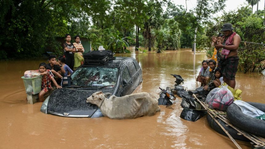 Flood-affected residents wait for a rescue boat to arrive in Taungoo, Myanmar, on September 14, 2024.