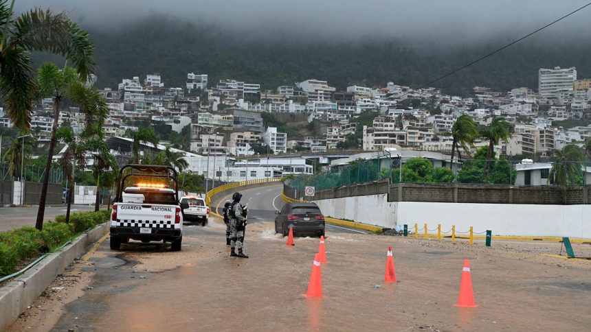 Security forces stands guard on a flooded road after Hurricane John in Acapulco, Mexico on September 26, 2024.