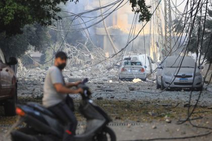 A man rides his motorbike through a devastated neighborhood in the Hadath district of Beirut's southern suburbs on Saturday following overnight Israeli airstrikes on the outskirts of the Lebanese capital.