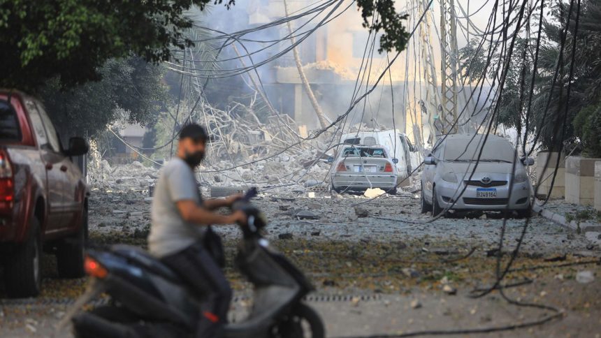 A man rides his motorbike through a devastated neighborhood in the Hadath district of Beirut's southern suburbs on Saturday following overnight Israeli airstrikes on the outskirts of the Lebanese capital.