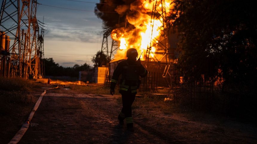 A Ukrainian firefighter talks on the radio while he works to extinguish the fire on the site of an electrical substation that was hit by Russian strike in Dnipropetrovsk region, Ukraine, Monday, Sept. 2, 2024.