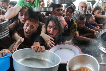 Palestinians receive food cooked by a charity kitchen in northern Gaza, September 11, 2024.