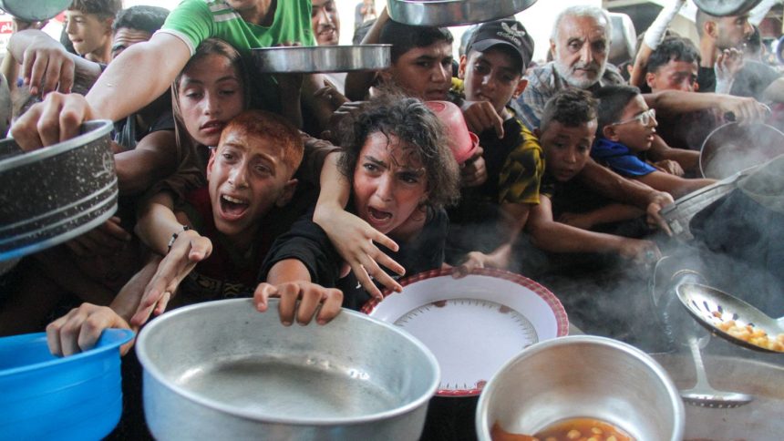 Palestinians receive food cooked by a charity kitchen in northern Gaza, September 11, 2024.