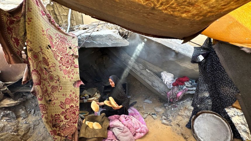 A Palestinian woman holds pita bread in a makeshift tent in Khan Younis, southern Gaza, on October 7, 2024.