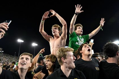 Oregon Ducks fans swarm the field after the game.