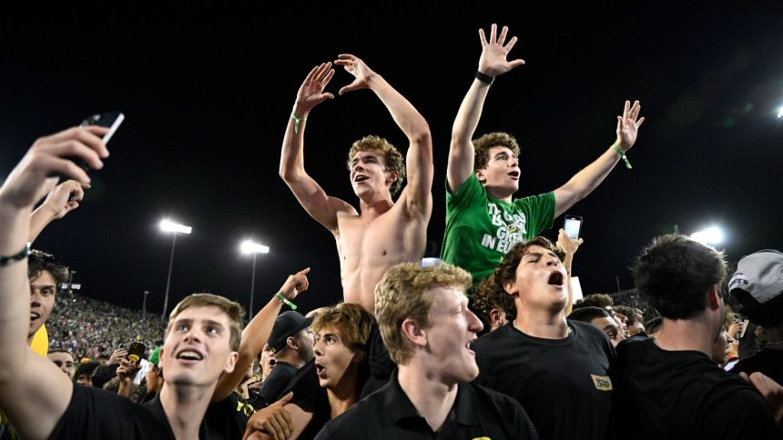 Oregon Ducks fans swarm the field after the game.