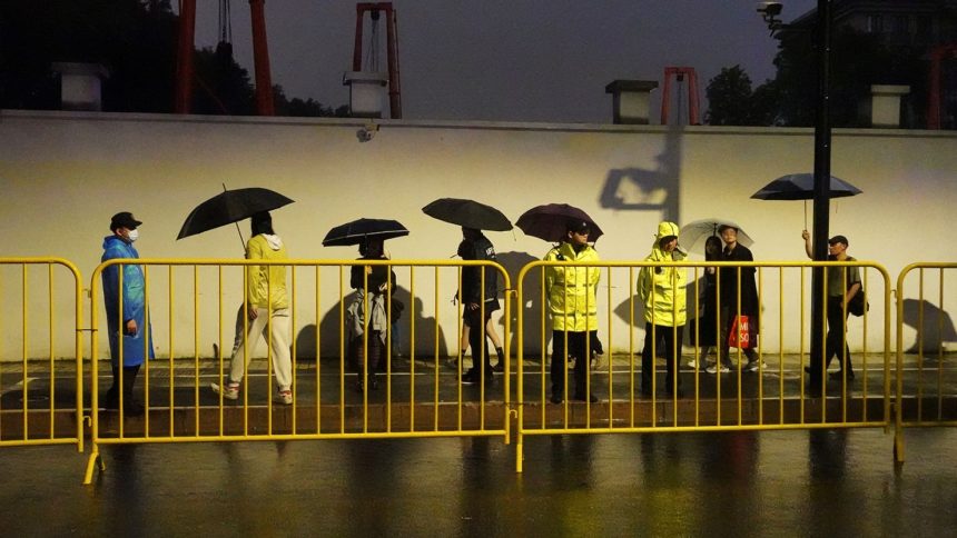 Police officers keep watch near barricades set up along Julu Road where people in Halloween costumes gathered the year before, in Shanghai, China October 26, 2024.