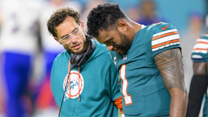 Miami Dolphins quarterback Tua Tagovailoa (right) walks off the field with head coach Mike McDaniel during the game against the Buffalo Bills.