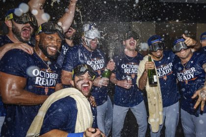 The New York Mets celebrate in the locker room after clinching a playoff berth with their come-from-behind victory against the Atlanta Braves.